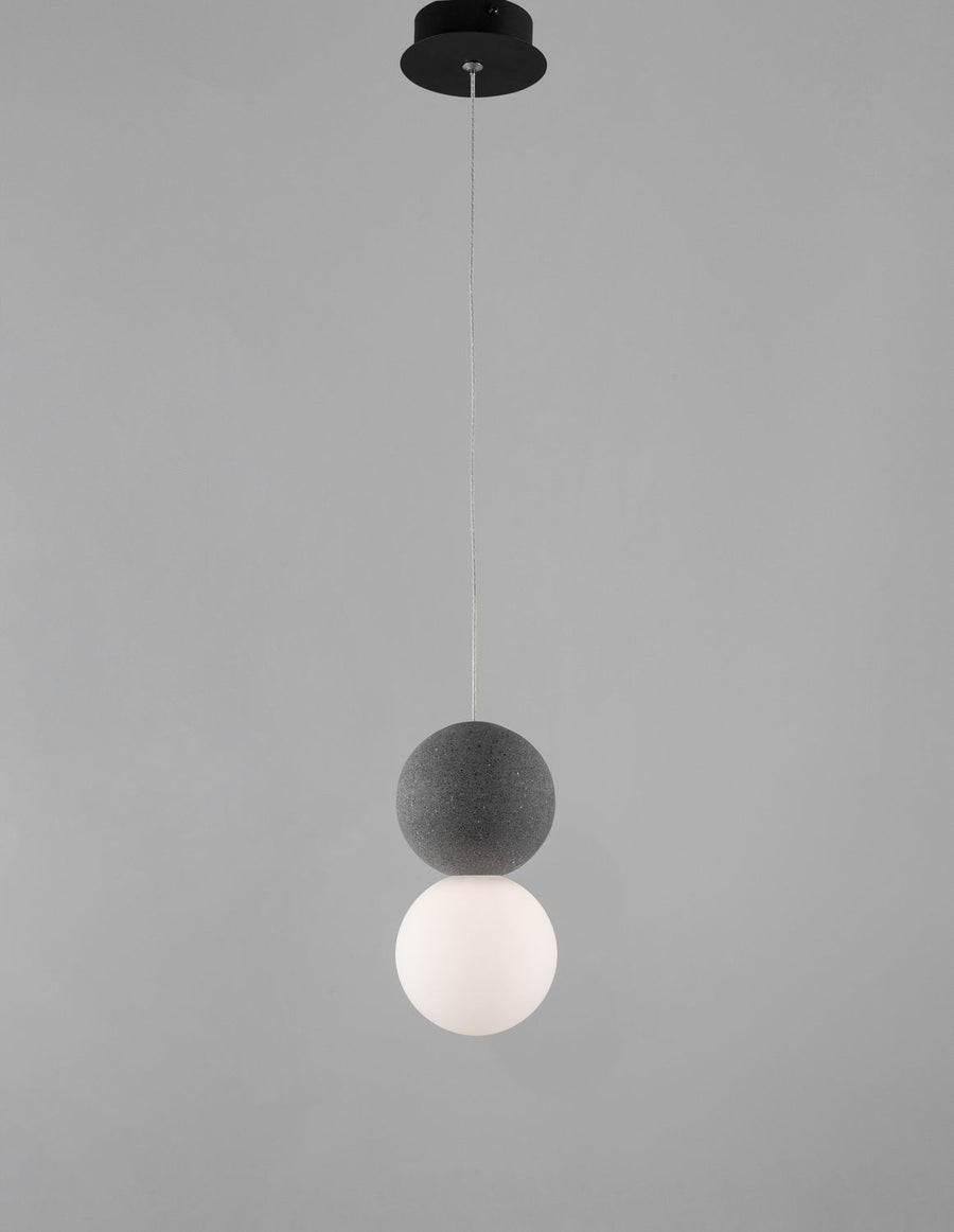 Luminaire suspendu présenté de face sur fond gris, rosace noire et câble tressé