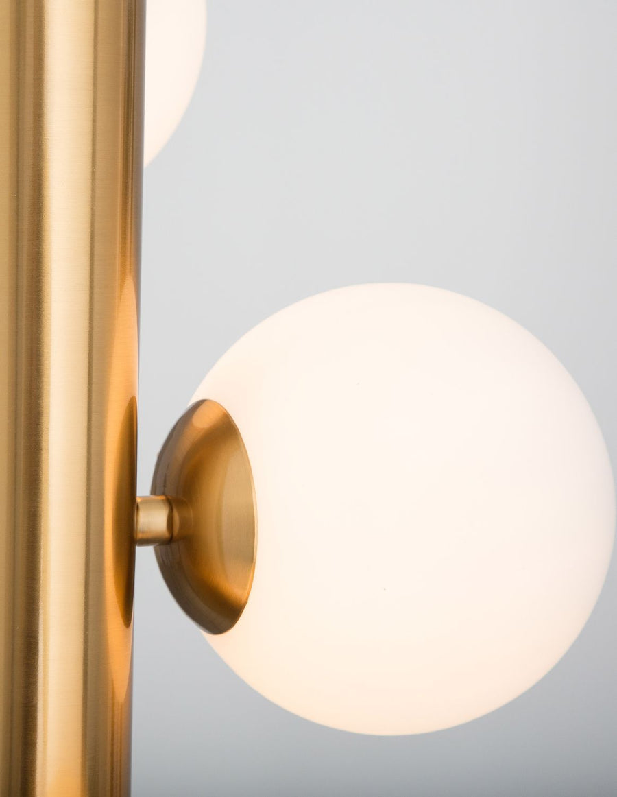 Zoom sur la douille dorée fixant une sphère de verre dépoli sur le montant