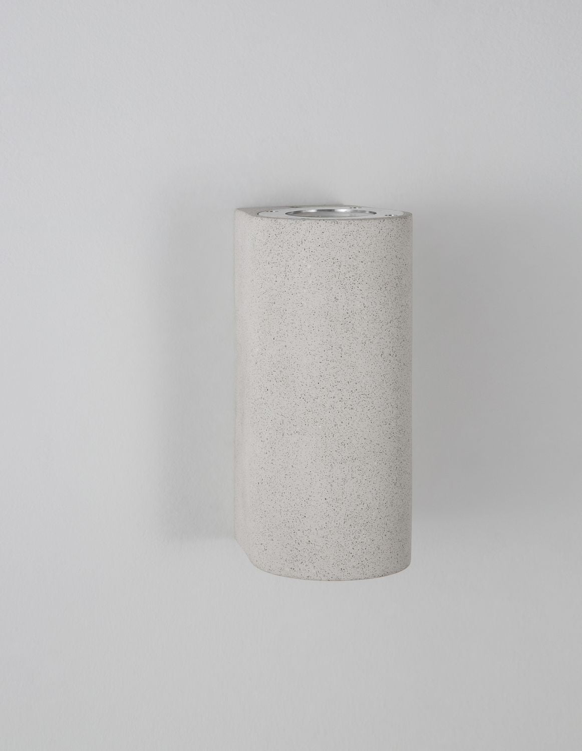 Vue de trois quarts sur fond gris, volume cylindrique et texture bétonné clair