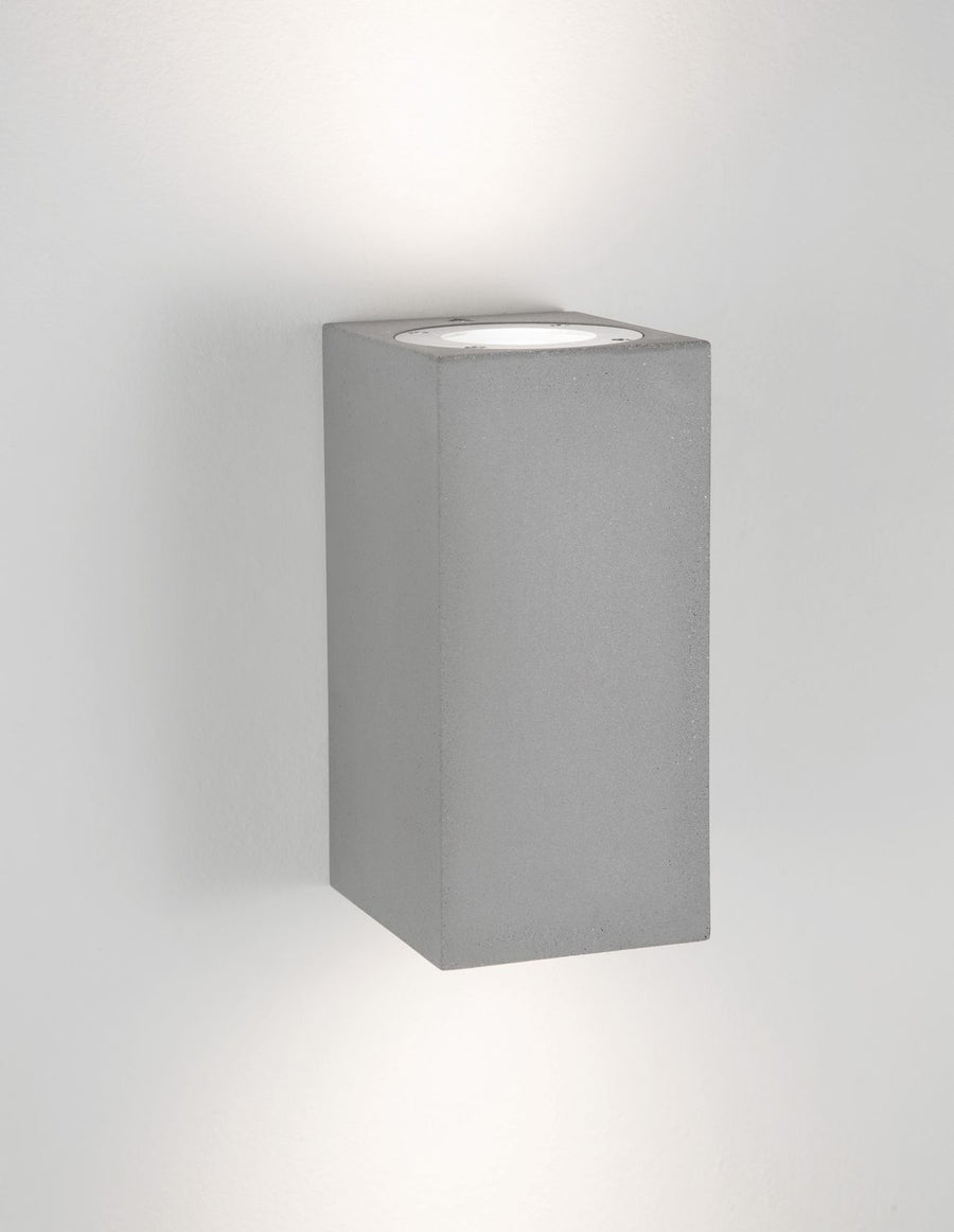 Applique allumée projetant une lumière chaude vers le haut du mur