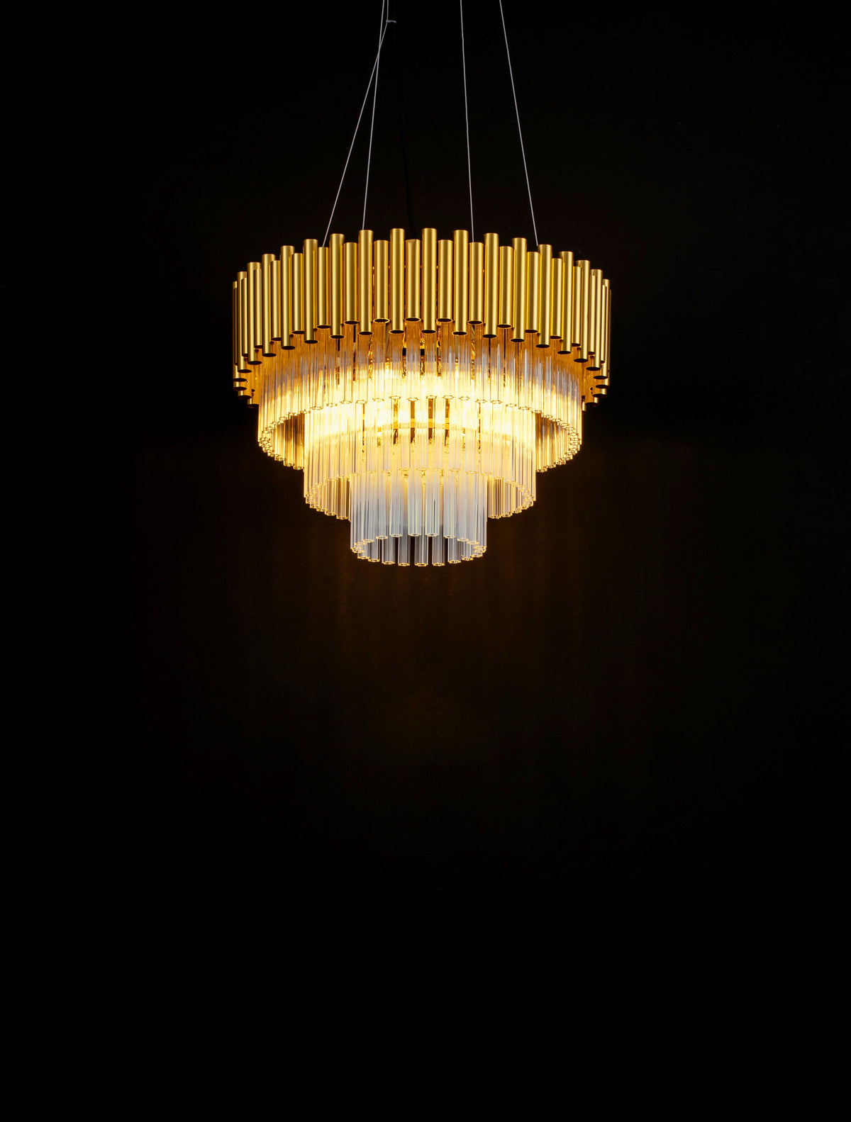 Luminaire allumé dans l'obscurité, mettant en valeur le cristal et la dorure.