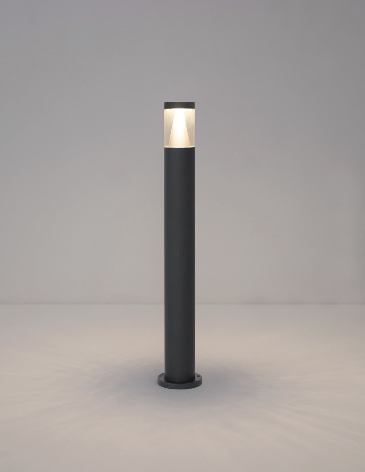 Borne allumée diffusant une lumière chaude en partie haute sur fond neutre.