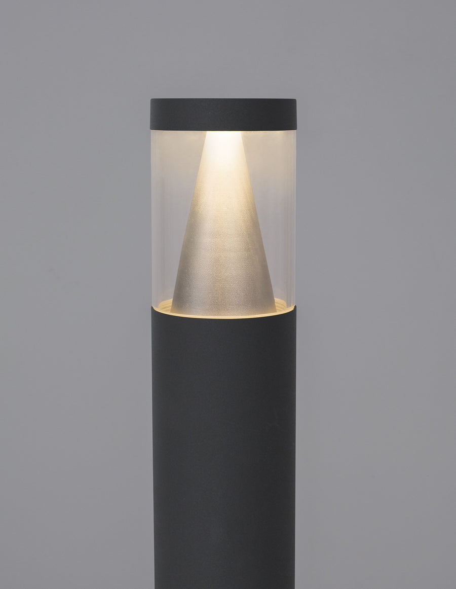 Détail rapproché de la tête allumée, cône strié et cylindre de verre transparent.