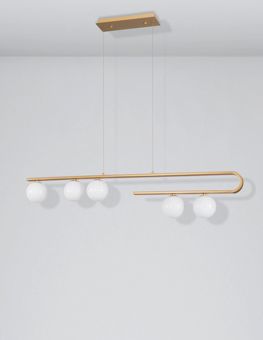 Luminaire présenté de face sur fond gris clair, barre dorée en boucle