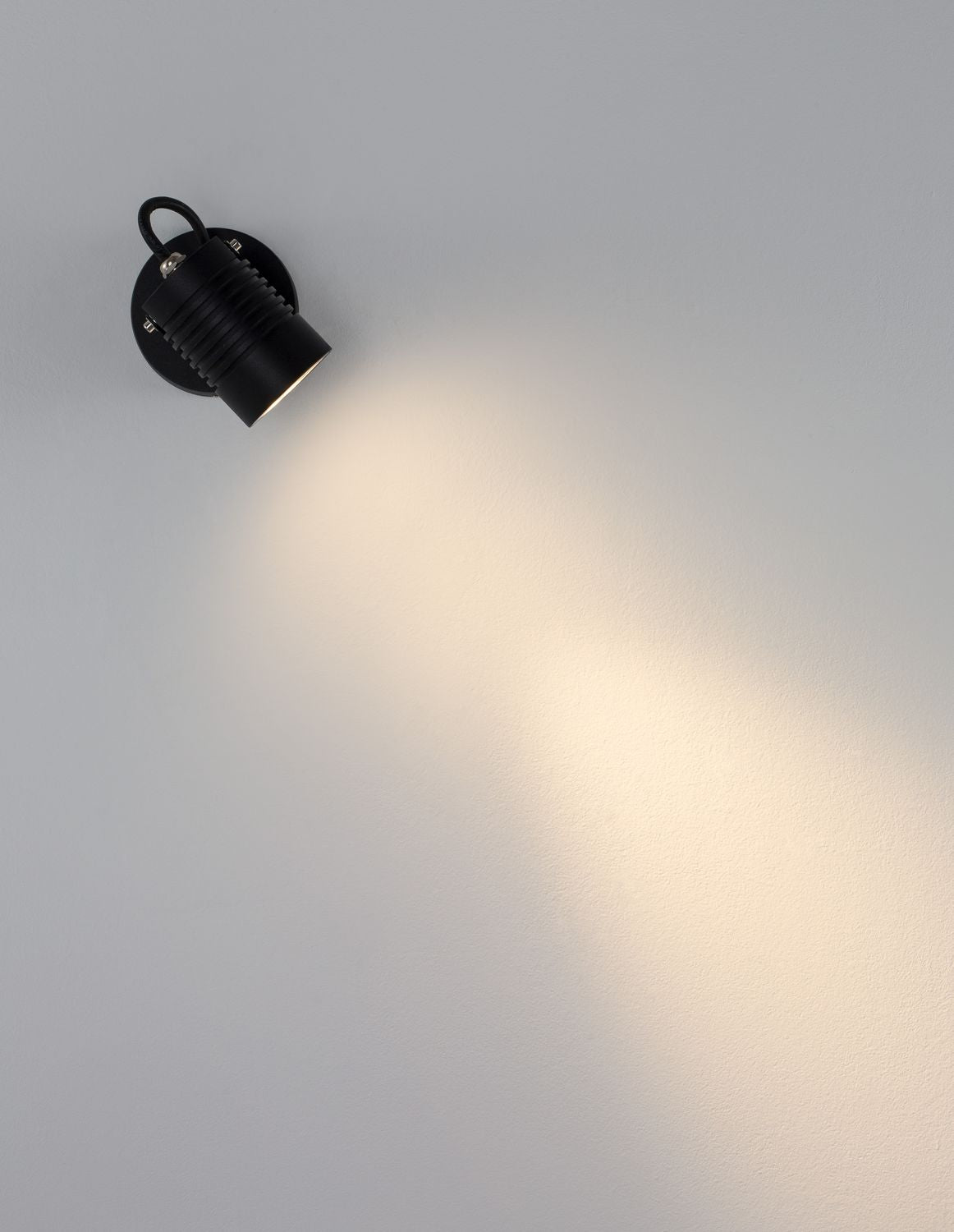 Vue en plongée de l'applique allumée projetant un large faisceau lumineux