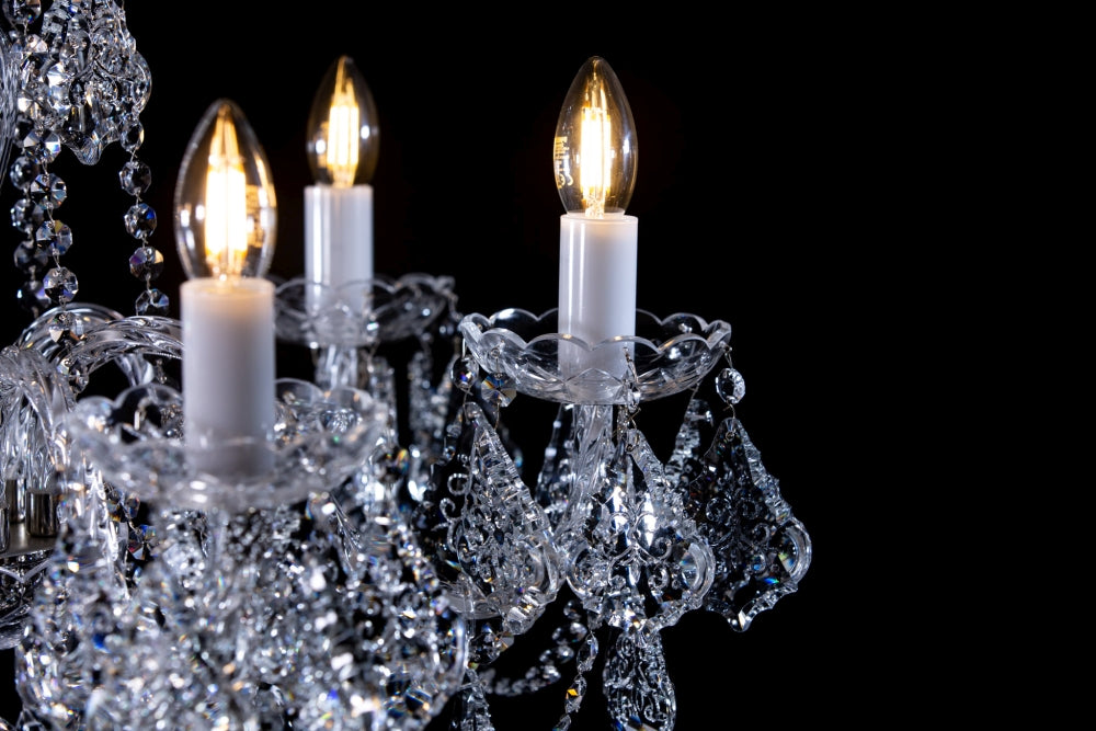 Trois ampoules flamme éclairées sur leurs douilles blanches et coupelles ciselées