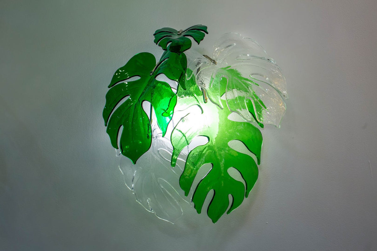 Détail rapproché de l'applique allumée, feuilles vertes et transparentes, lumière diffusée