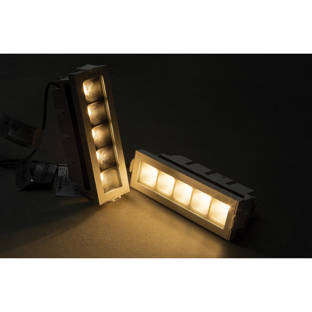Autre angle des deux modules LED allumés, éclairage doré sur surface sombre.