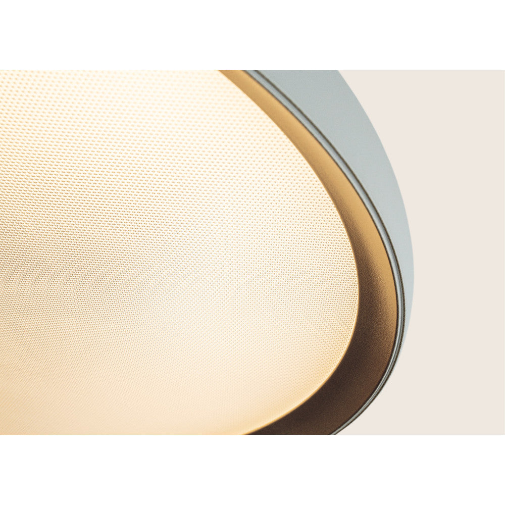 Détail rapproché du liseré doré et du diffuseur perforé en lumière chaude.