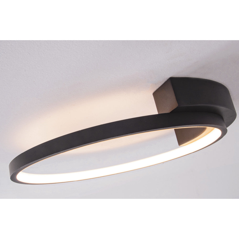 Vue rapprochée du plafonnier allumé montrant l'anneau noir et le diffuseur blanc.