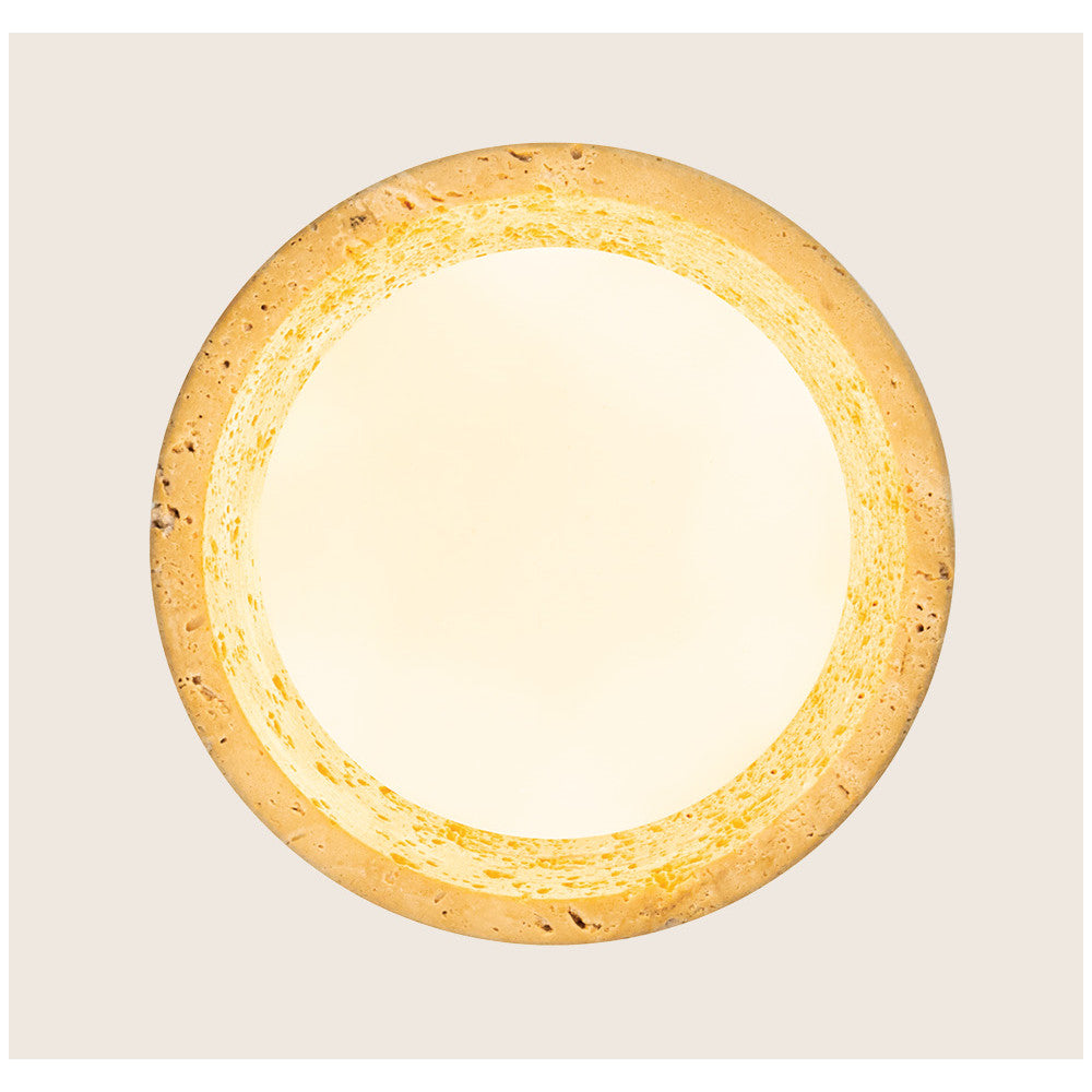 Détail du cercle en pierre travertin ajourée éclairée par la lumière chaude