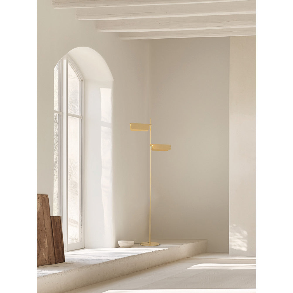 Mise en ambiance dans un intérieur épuré, lampadaire doré près d'une fenêtre arquée