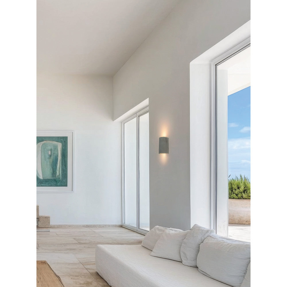 Mise en ambiance dans un séjour lumineux, applique allumée entre deux baies vitrées