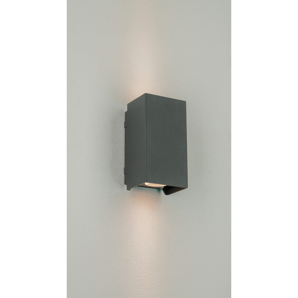 Applique installée sur un mur blanc, éclairant vers le bas et le haut.