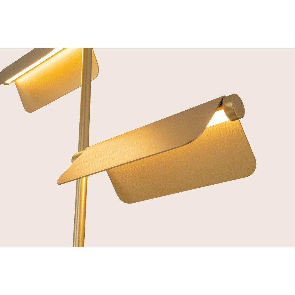 Gros plan sur une tête de lampe allumée, abat-jour rectangulaire et finition dorée brossée