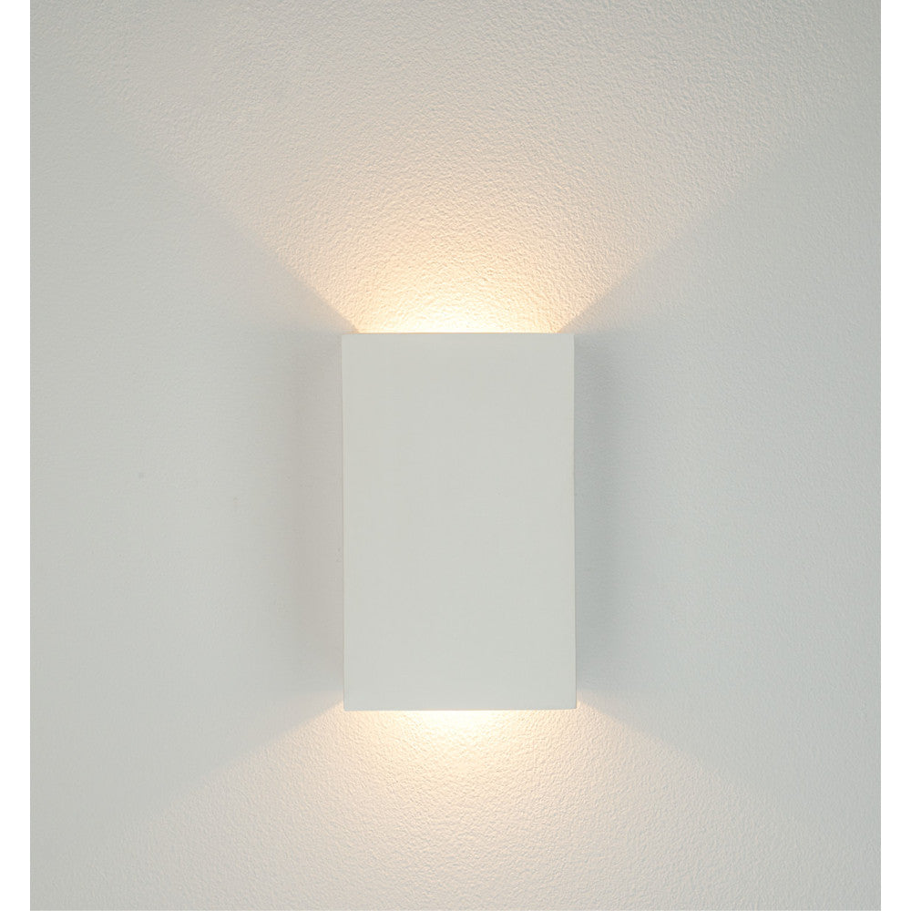 Vue frontale de l'applique blanche fixée sur un mur clair