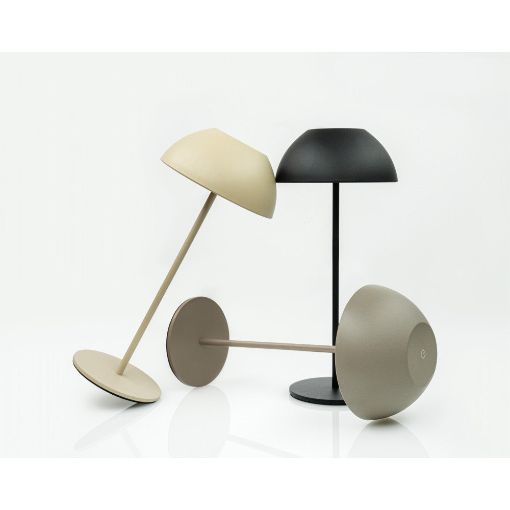 Trois lampes de table présentées inclinées et debout, montrant les coloris sable, noir et taupe.