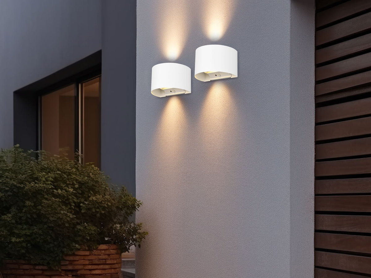 Mise en ambiance nocturne de deux appliques sur un mur gris extérieur