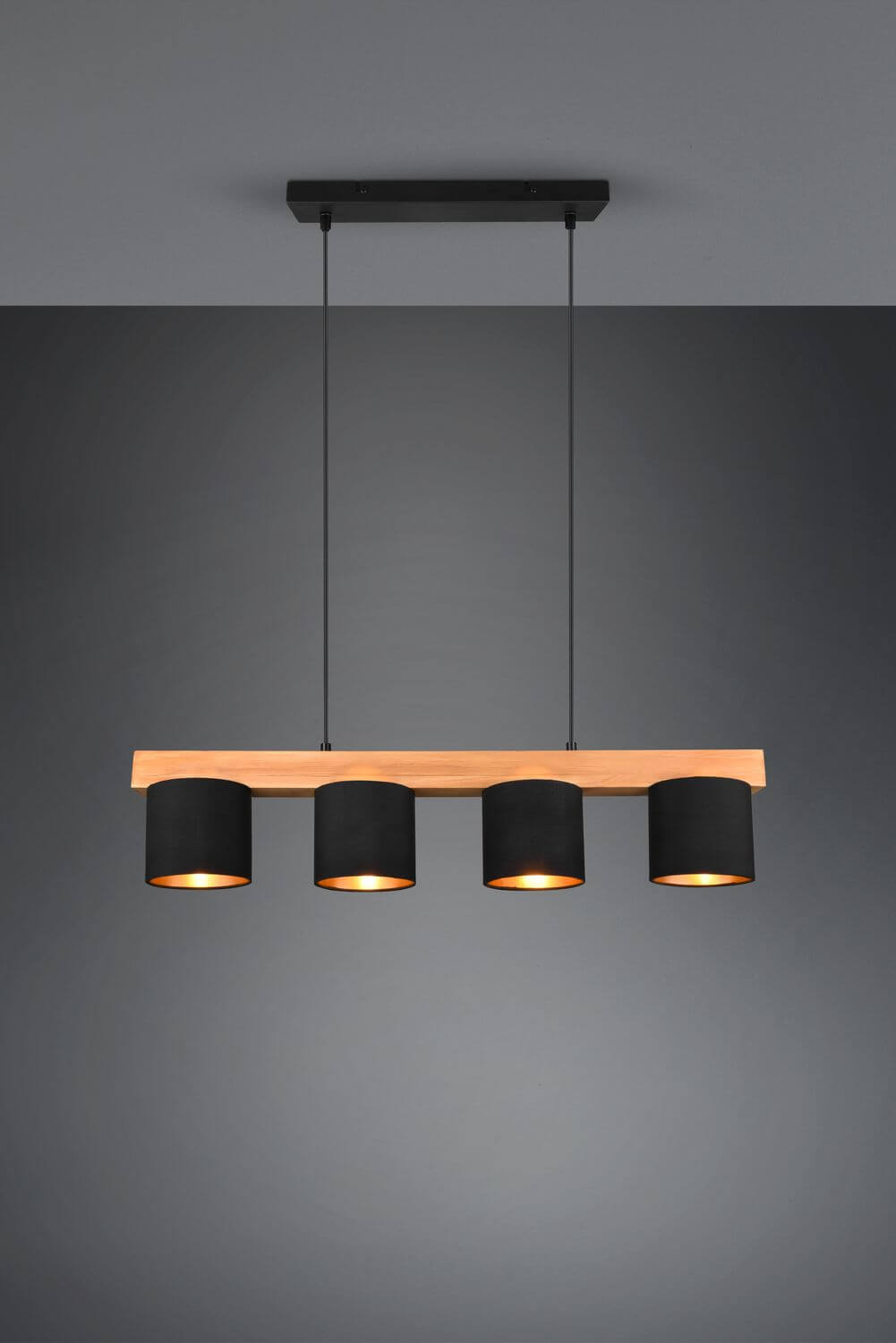 Vue de face du luminaire allumé, câbles noirs et abat-jours cylindriques suspendus