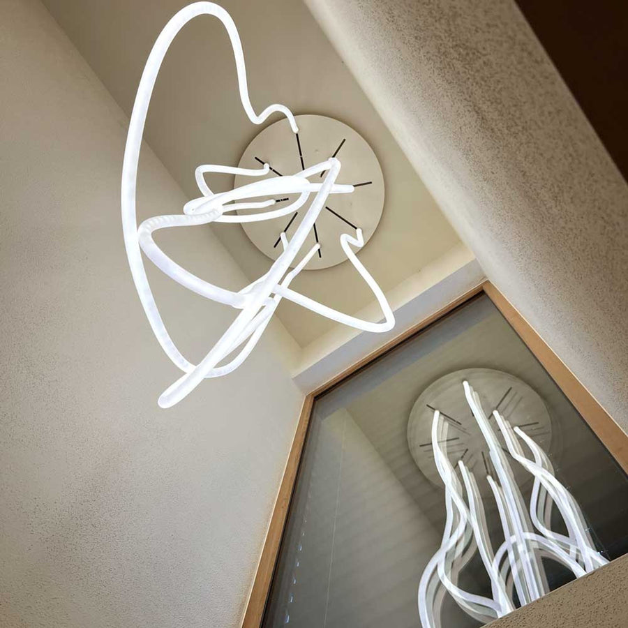 Vue en contre-plongée du luminaire fixé au plafond et son reflet.