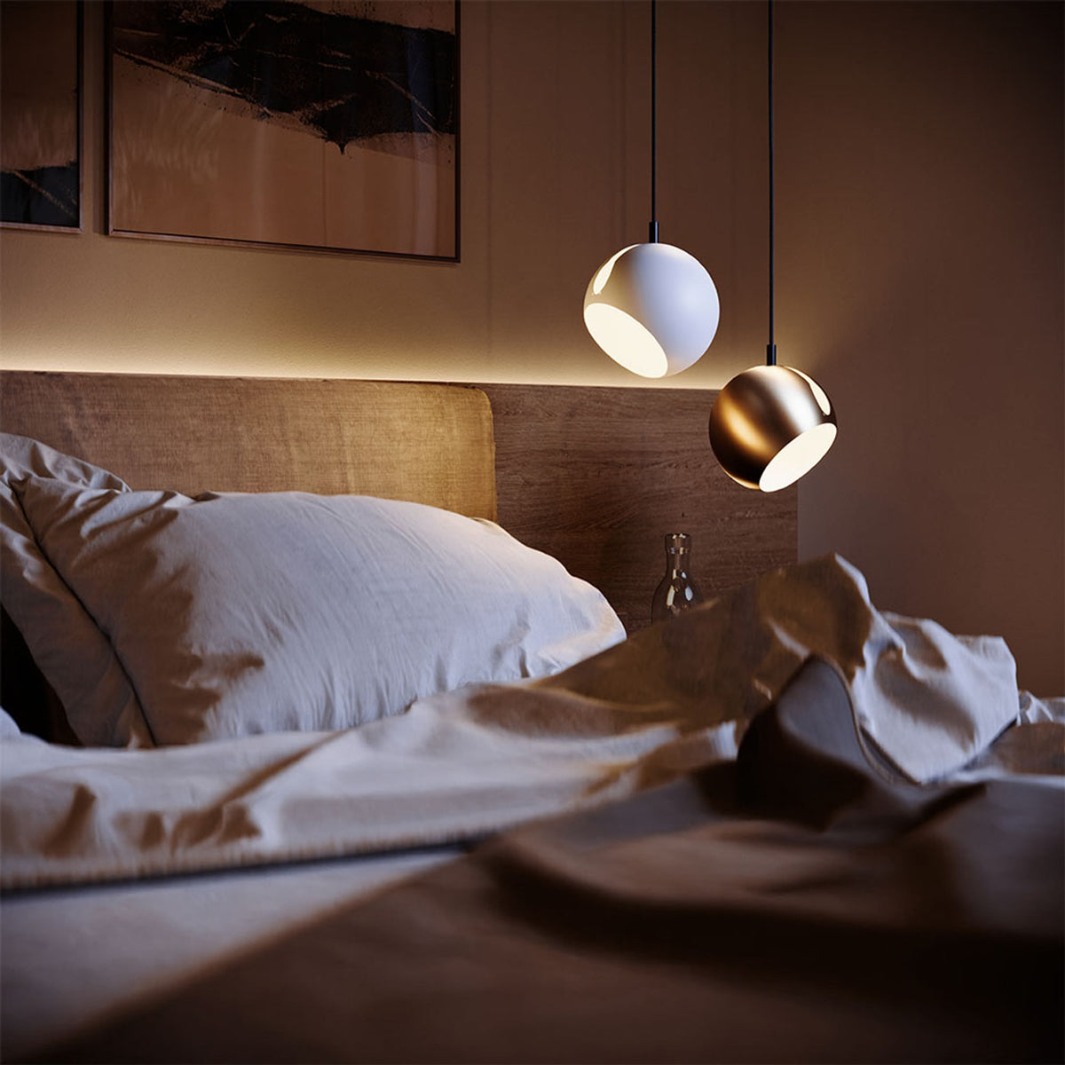 Deux petites suspensions boule blanche et dorée au-dessus d'un lit froissé