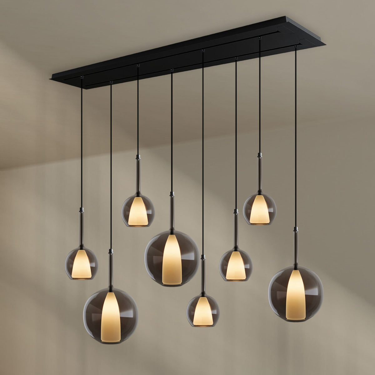 Détail des globes en verre ambré et des tiges cuivrées de la suspension.