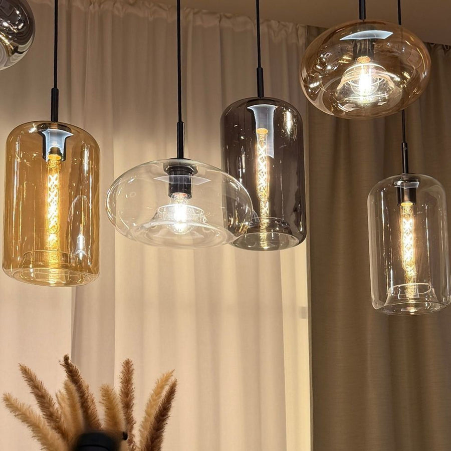 Gros plan sur les verres ambré, fumé et transparent d'une collection de suspensions