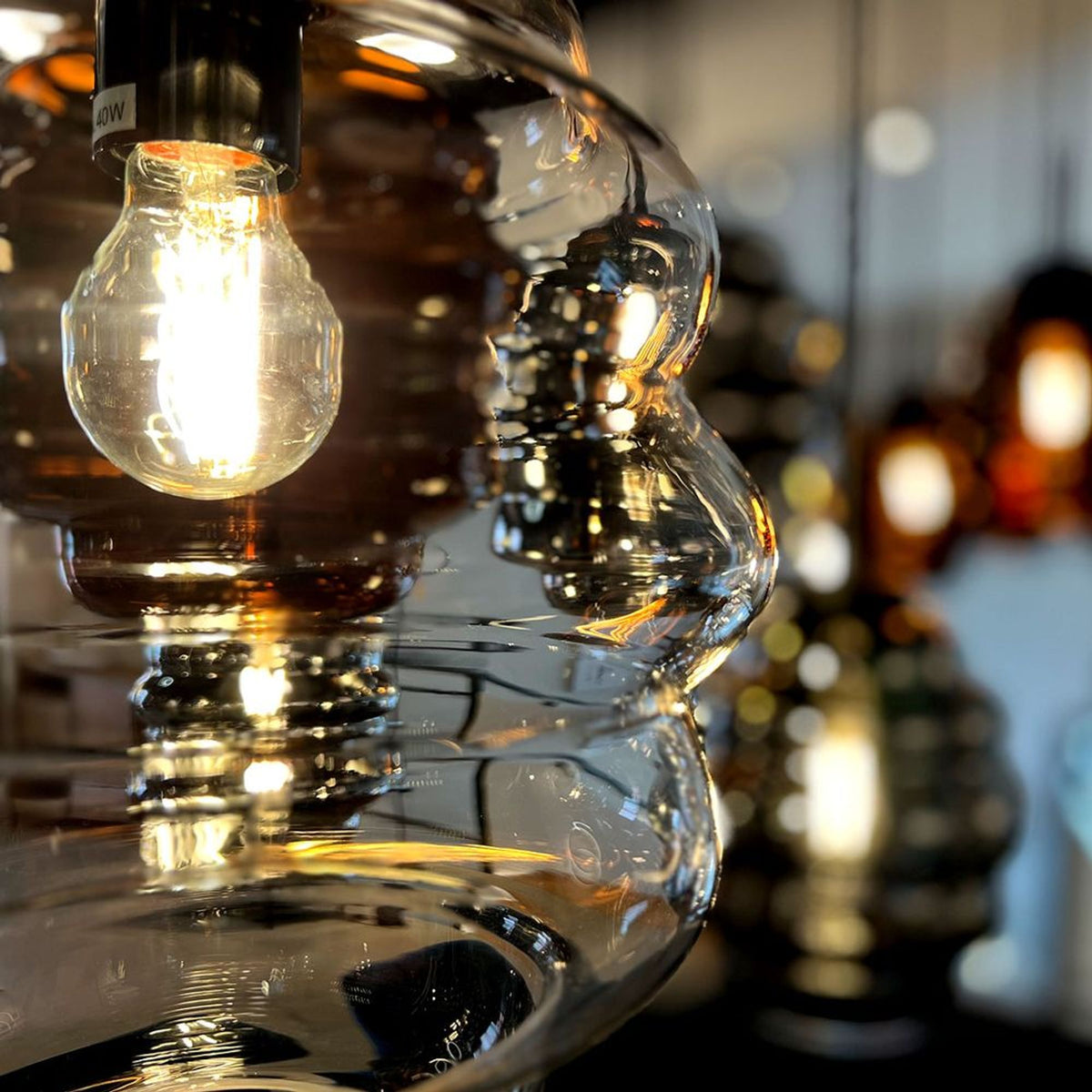 Très gros plan sur la texture ondulée du verre et l'ampoule marquée 40W