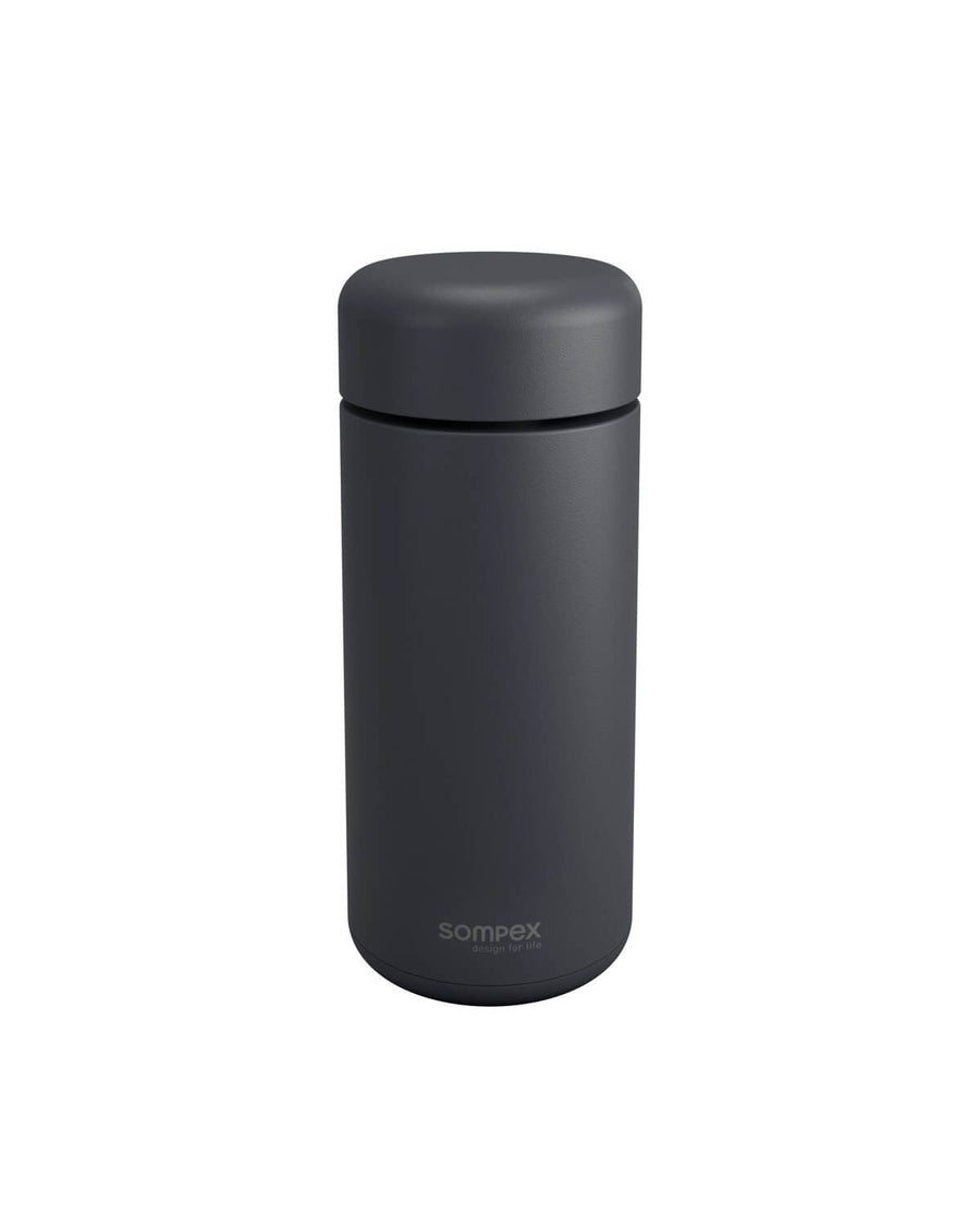 Lampe portable éteinte, capot clipsé sur le corps cylindrique, fond blanc neutre