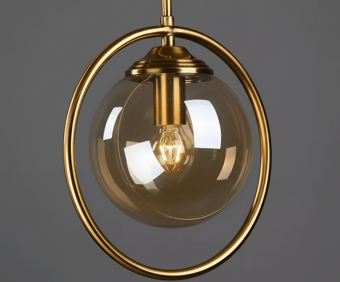 Gros plan sur la boule de verre ambré, la douille dorée et les reflets