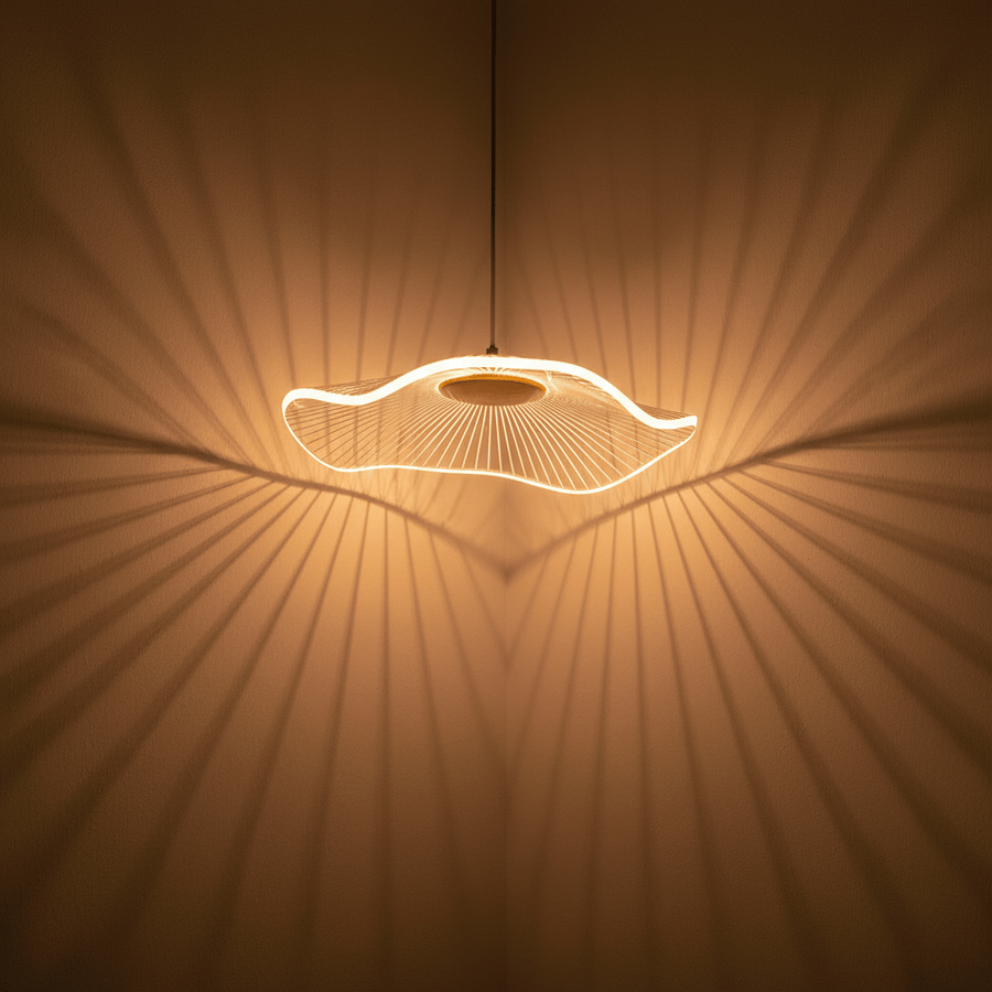 Ombres rayonnantes projetées sur le mur par le luminaire allumé, détail de l'éclairage.