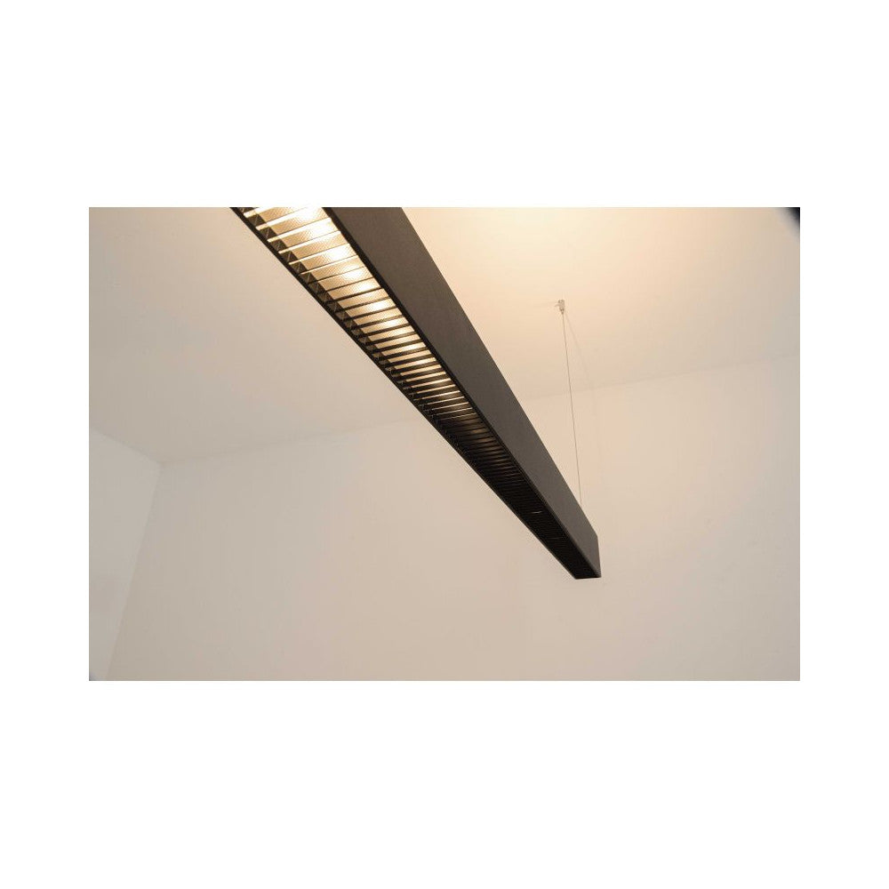 Détail rapproché de la grille alvéolée laissant filtrer une lumière chaude vers le haut