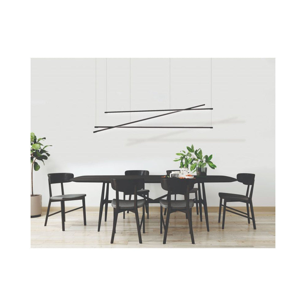 Luminaire suspendu au-dessus d'une table à manger noire entourée de chaises