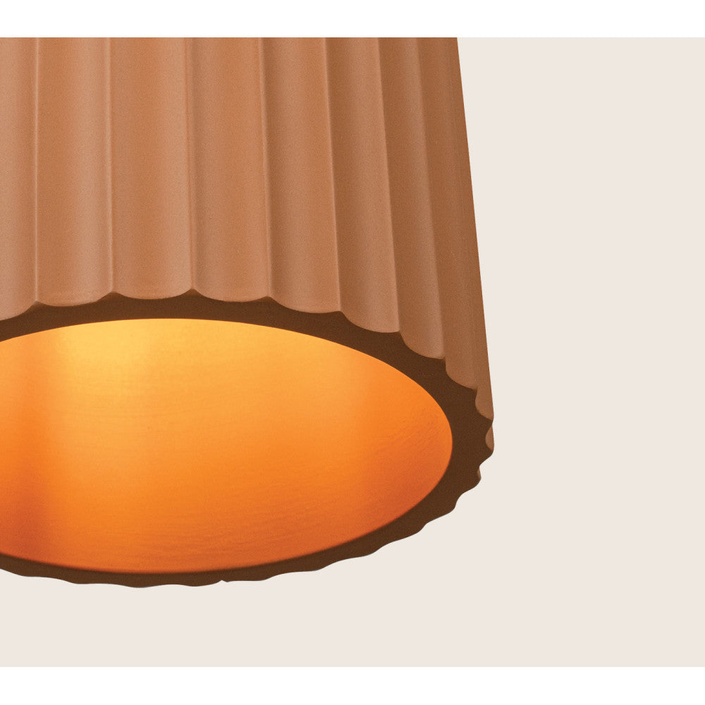 Détail du bord inférieur ondulé et du halo lumineux chaud du luminaire