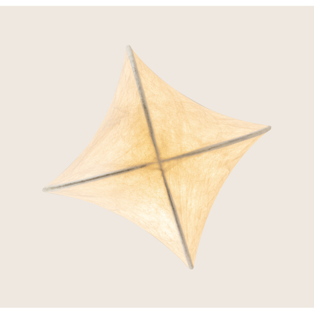 Abat-jour en textile plissé formant une étoile à quatre branches sur fond beige.
