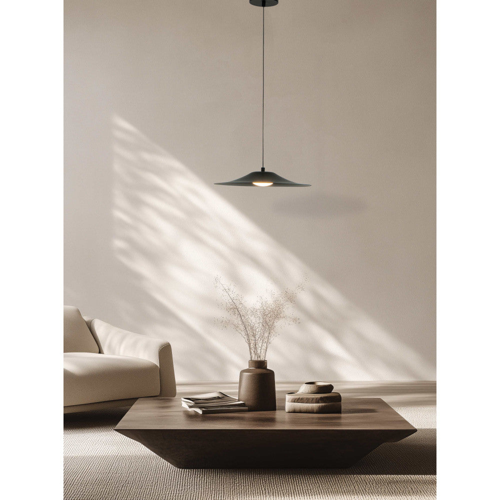 Ambiance salon épuré, suspension noire allumée au-dessus d'une table basse en bois