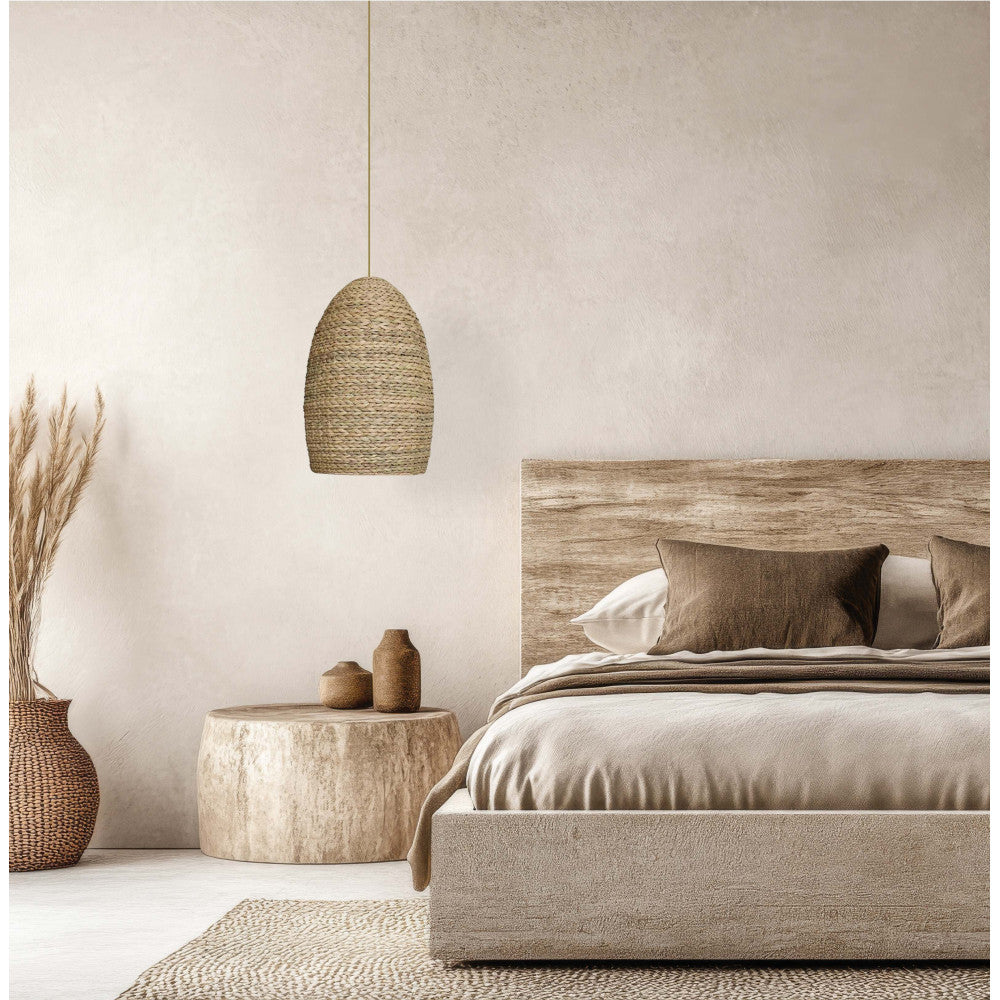 Vue rapprochée de la chambre, suspension rotin tressé, table bois et vase d'herbes séchées