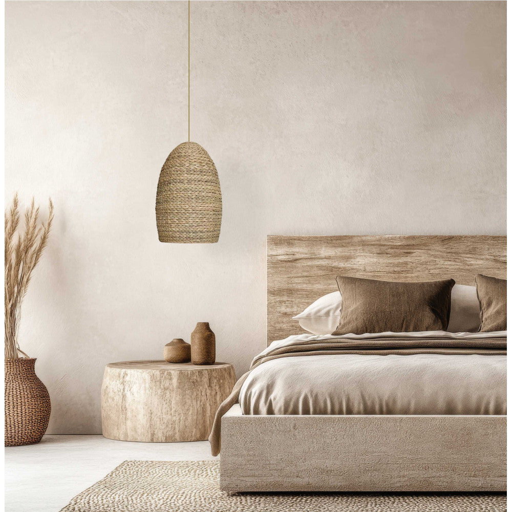 Ambiance chambre naturelle, suspension en rotin tressé près d'une table en bois brut