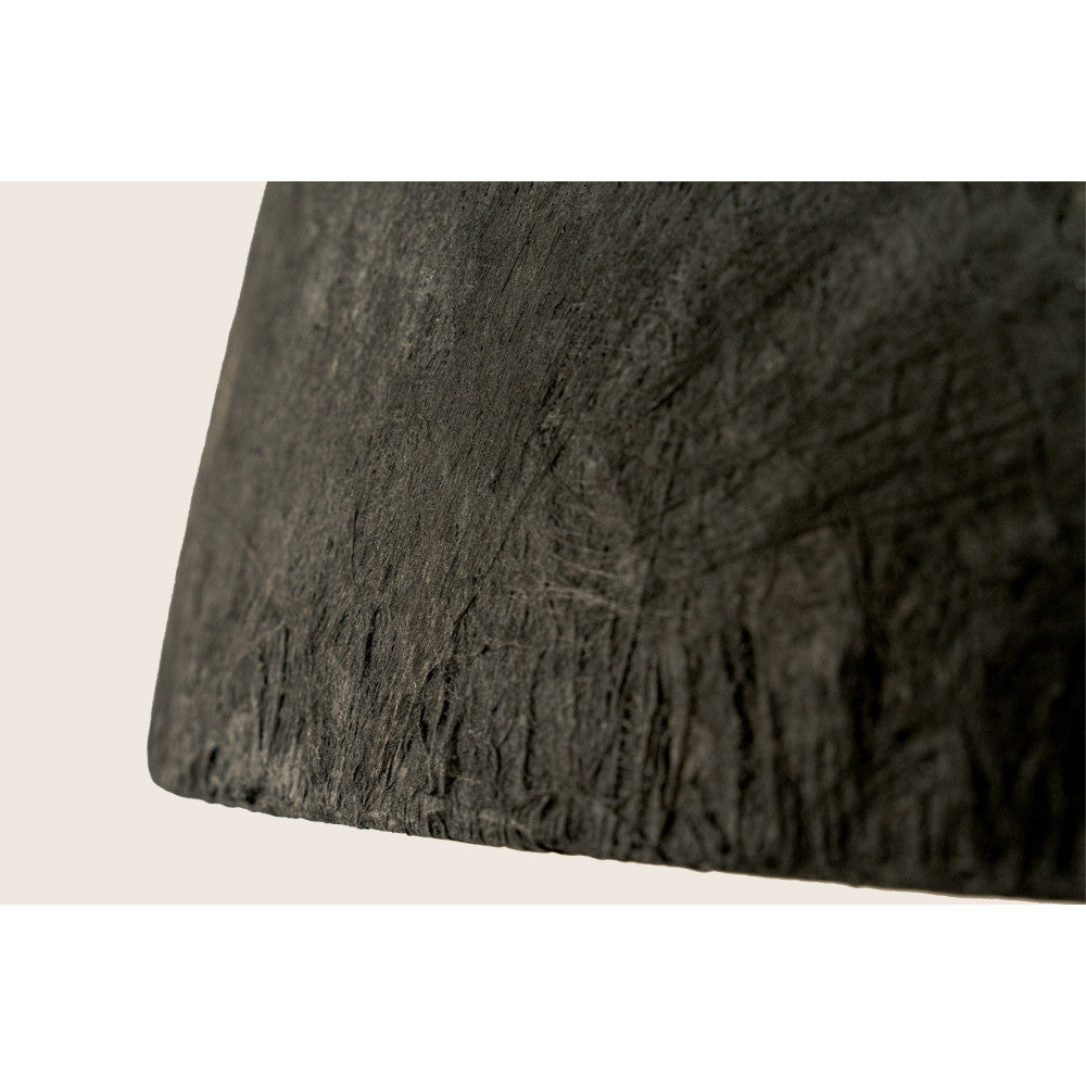 Détail macro de la surface extérieure noire, plissée et granuleuse, finition artisanale