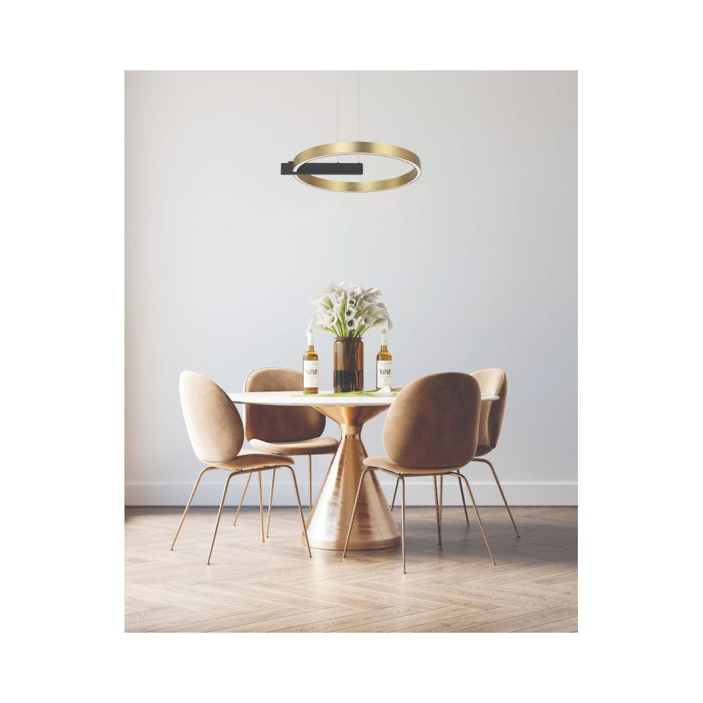 Suspension dorée installée au-dessus d'une table à manger avec chaises beiges.