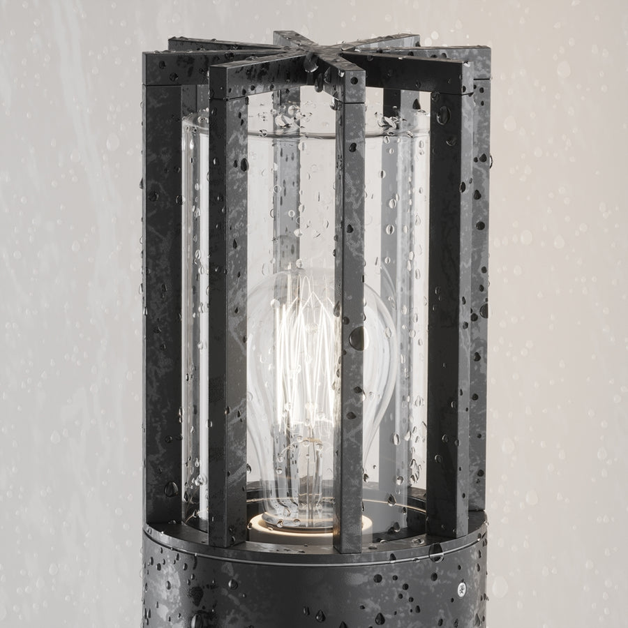 Gros plan sous la pluie, gouttes d'eau sur la cage noire et le verre du luminaire.