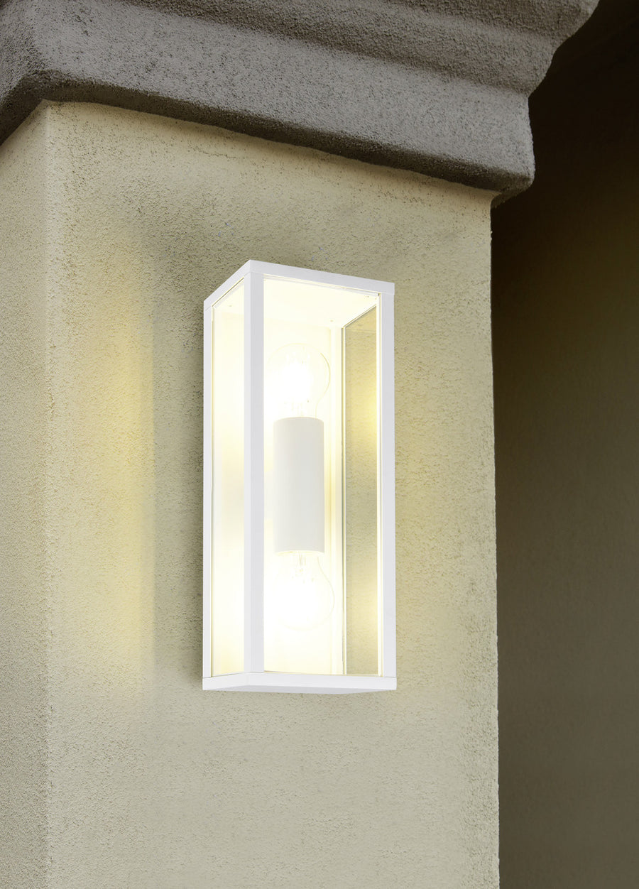 Applique installée sur un mur crépit beige sous une corniche en pierre, lumière allumée