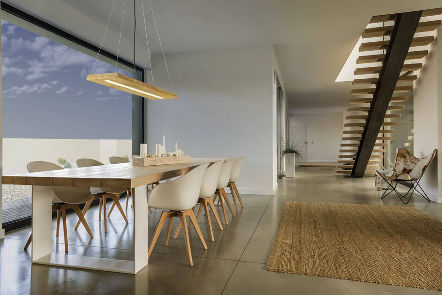 Vue d'ensemble d'un intérieur moderne, suspension en bois au-dessus de la grande table.