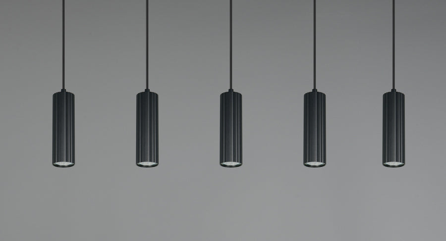 Vue rapprochée des cinq cylindres noirs cannelés suspendus sur fond gris.