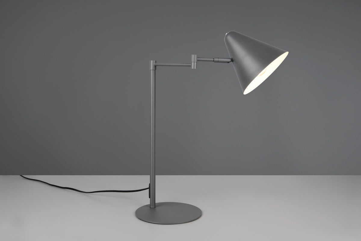 Mise en ambiance grise, lampe posée sur surface claire avec ombre portée.