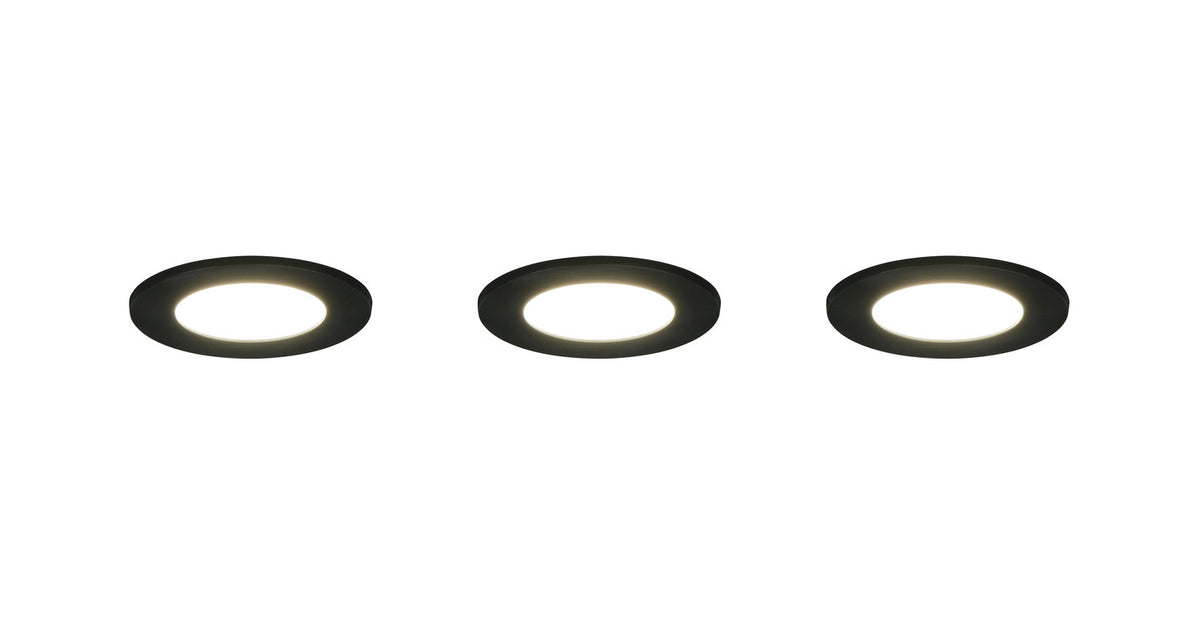 Trois spots encastrables noirs allumés avec halo lumineux blanc et collerette noire