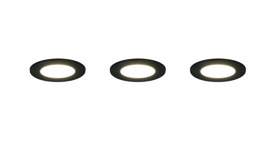 Trois spots encastrables noirs allumés avec halo lumineux blanc et collerette noire
