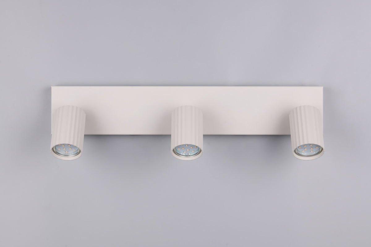 Vue de face du spot plafond blanc avec trois têtes cylindriques cannelées.