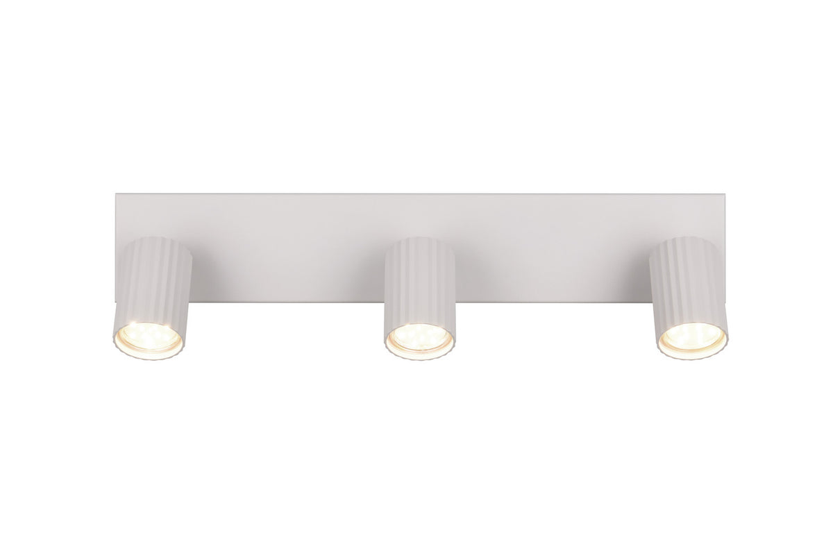 Spot blanc allumé, trois projecteurs orientables diffusant une lumière chaude.