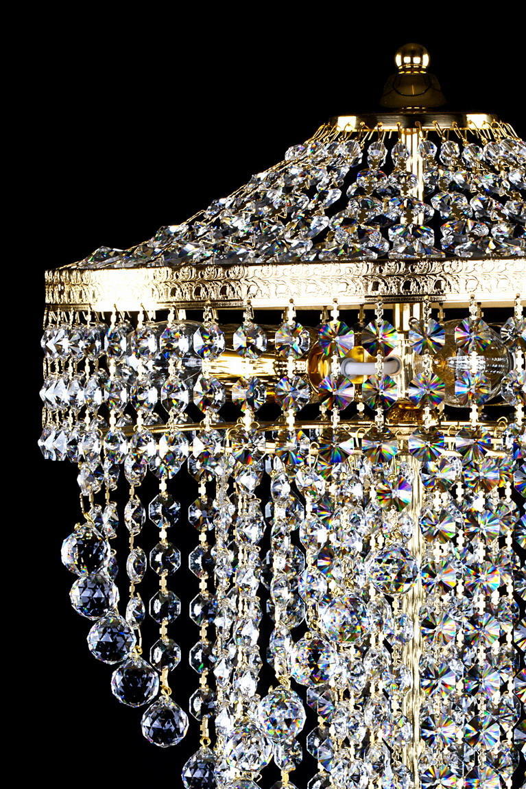 Détail de la bague dorée ciselée et des strass taillés près de la douille